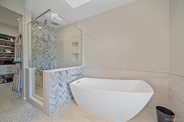 bathroom featuring plus walk in shower, tile walls, and tile patterned flooring