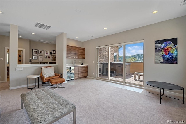 living area featuring light colored carpet and wet bar