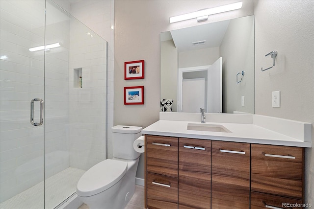 bathroom featuring walk in shower, vanity, toilet, and tile patterned floors