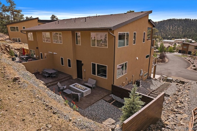 exterior space featuring a patio, cooling unit, an outdoor fire pit, and a mountain view