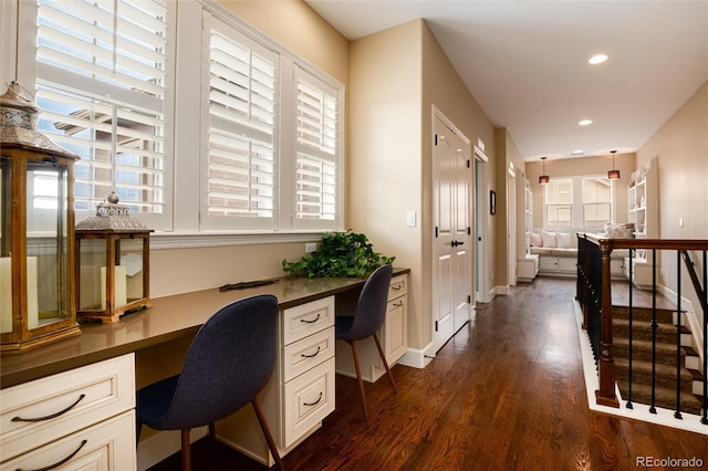 office area with dark wood-type flooring and built in desk