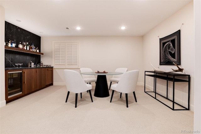 carpeted dining room with wet bar and beverage cooler