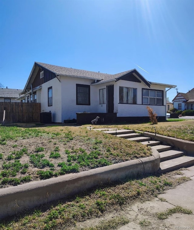 ranch-style home featuring fence