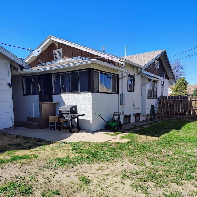 rear view of property with fence, a sunroom, and a yard