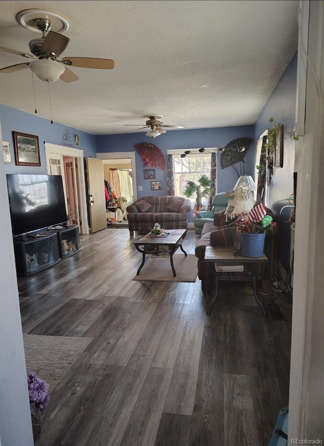 living room featuring ceiling fan, wood finished floors, and a textured ceiling