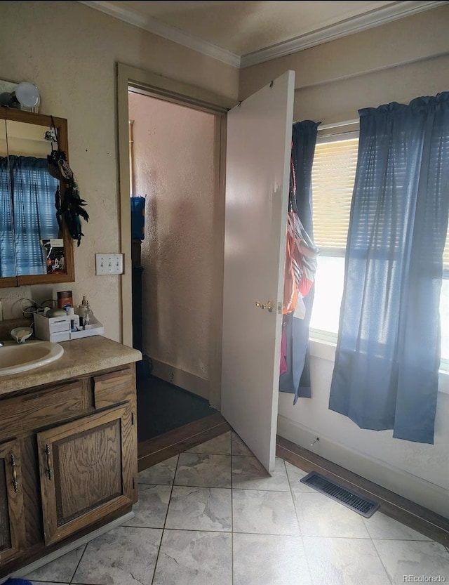 bathroom featuring visible vents, vanity, and ornamental molding
