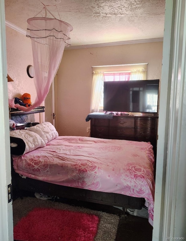 bedroom with a textured ceiling and crown molding