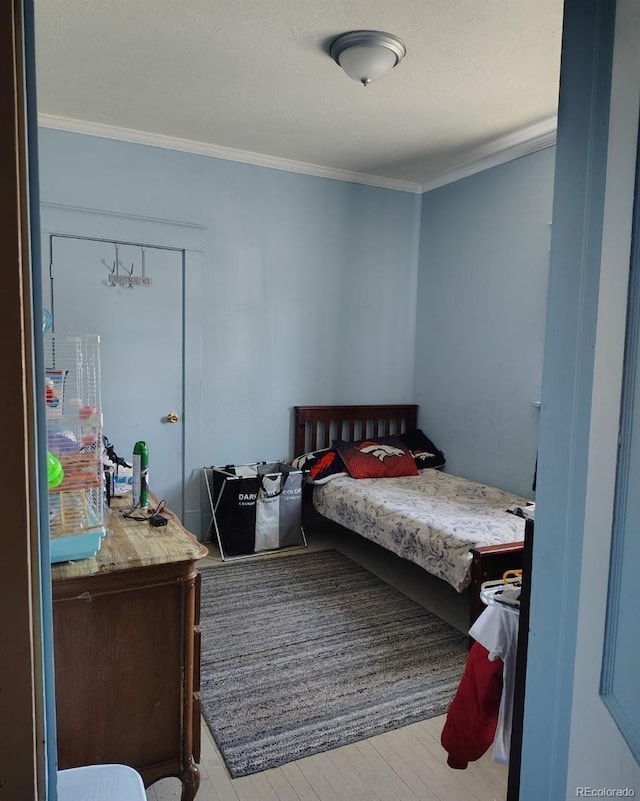 bedroom featuring crown molding and wood finished floors