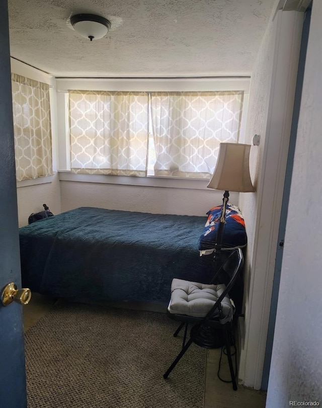 carpeted bedroom featuring a textured ceiling