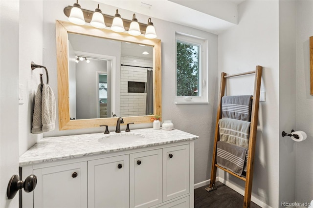 full bath with vanity and baseboards