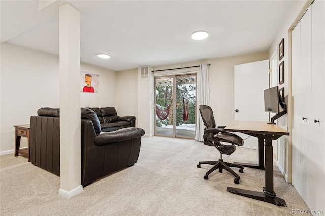 office space with baseboards, visible vents, and light carpet