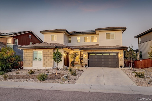 view of front of property with a garage and solar panels