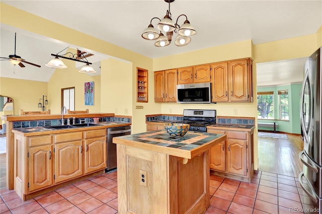 9682 Hemlock Ct, Highlands Ranch, CO 80130 - kitchen with appliances with stainless steel finishes, a kitchen island, a peninsula, a chandelier, and a ceiling fan