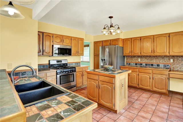 9682 Hemlock Ct, Highlands Ranch, CO 80130 - kitchen featuring appliances with stainless steel finishes, a chandelier, light tile patterned floors, a center island, and tasteful backsplash