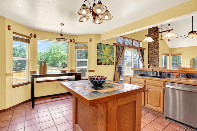 9682 Hemlock Ct, Highlands Ranch, CO 80130 - kitchen with stainless steel dishwasher, tile countertops, plenty of natural light, and light tile patterned floors