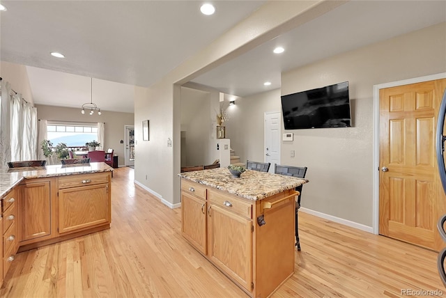 31324 Kings Vly, Conifer, CO 80433 - kitchen with light wood-type flooring, baseboards, recessed lighting, light stone countertops, and decorative light fixtures