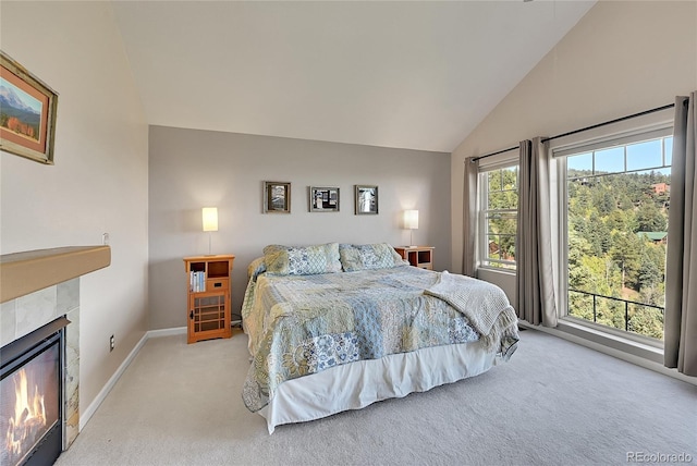 31324 Kings Vly, Conifer, CO 80433 - bedroom featuring carpet floors, a tiled fireplace, baseboards, and high vaulted ceiling