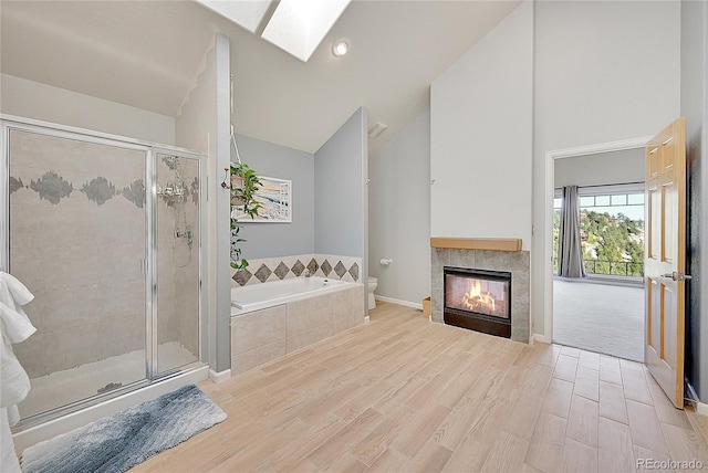 31324 Kings Vly, Conifer, CO 80433 - full bath with vaulted ceiling, a garden tub, a stall shower, toilet, and a fireplace