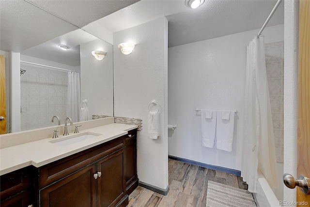 31324 Kings Vly, Conifer, CO 80433 - full bath with wood finished floors, vanity, shower / bath combo, and baseboards
