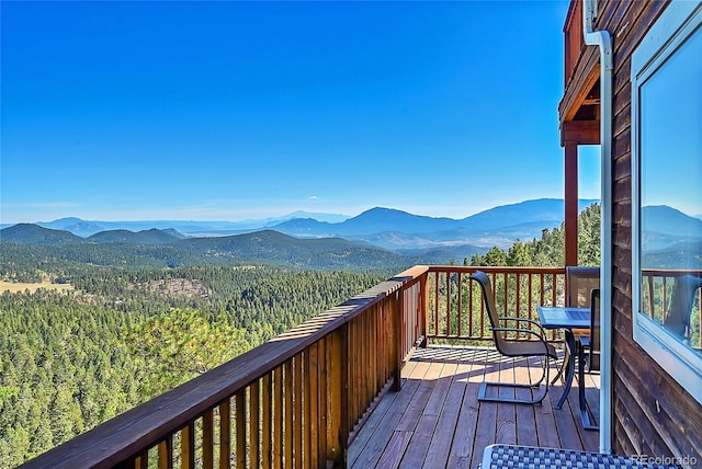 31324 Kings Vly, Conifer, CO 80433 - wooden deck with a mountain view, outdoor dining area, and a view of trees
