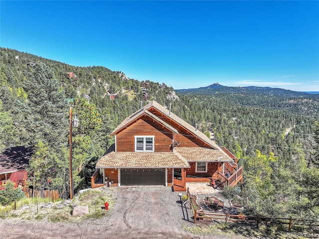 31324 Kings Vly, Conifer, CO 80433 - chalet / cabin with a view of trees, a garage, fence, and driveway