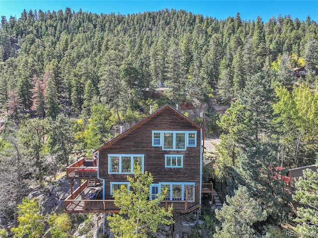 31324 Kings Vly, Conifer, CO 80433 - rear view of property featuring a view of trees and a wooden deck