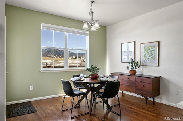 dining area featuring dark wood-type flooring, a mountain view, and a notable chandelier