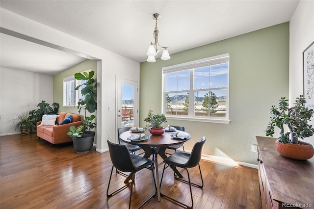 dining area with a notable chandelier and dark hardwood / wood-style flooring