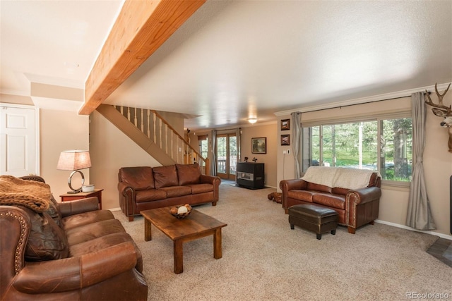 living room with beam ceiling and light colored carpet