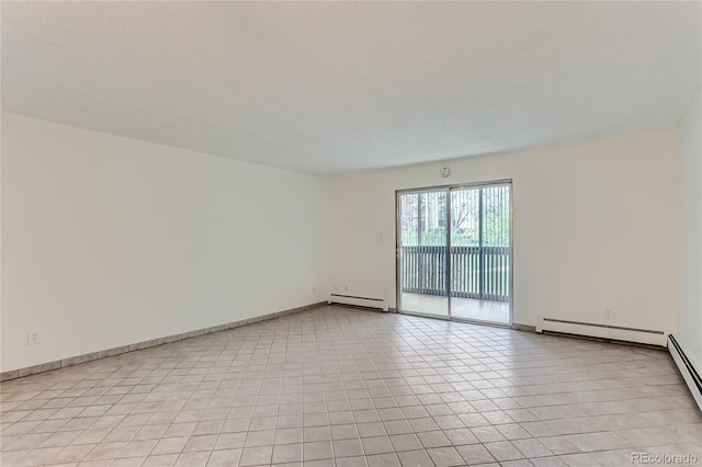 empty room with light tile patterned floors and a baseboard heating unit