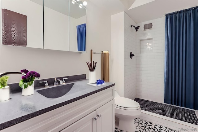 bathroom featuring tiled shower, tile patterned flooring, vanity, and toilet