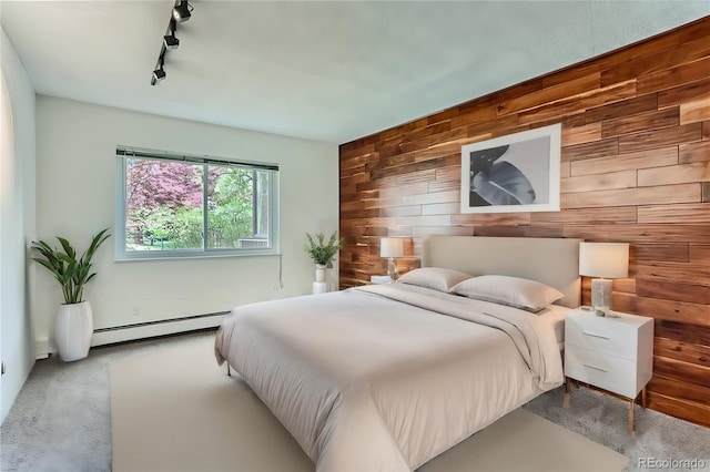 bedroom with a baseboard heating unit, track lighting, and wooden walls