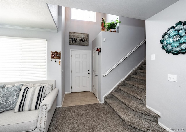 carpeted entryway featuring a textured ceiling