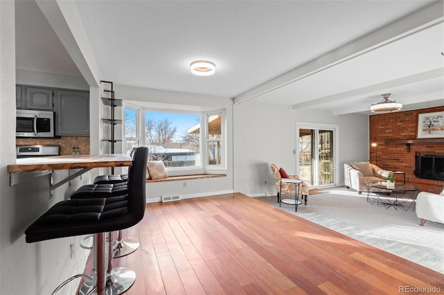 home office featuring light wood-type flooring and a fireplace