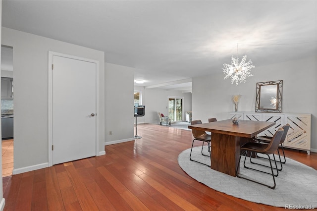 dining space featuring hardwood / wood-style flooring and a chandelier