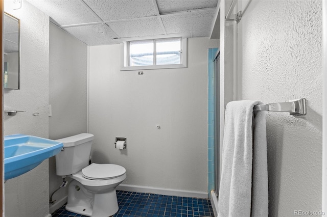 bathroom with toilet, a paneled ceiling, and walk in shower