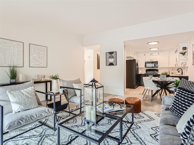 living room featuring sink and light hardwood / wood-style floors