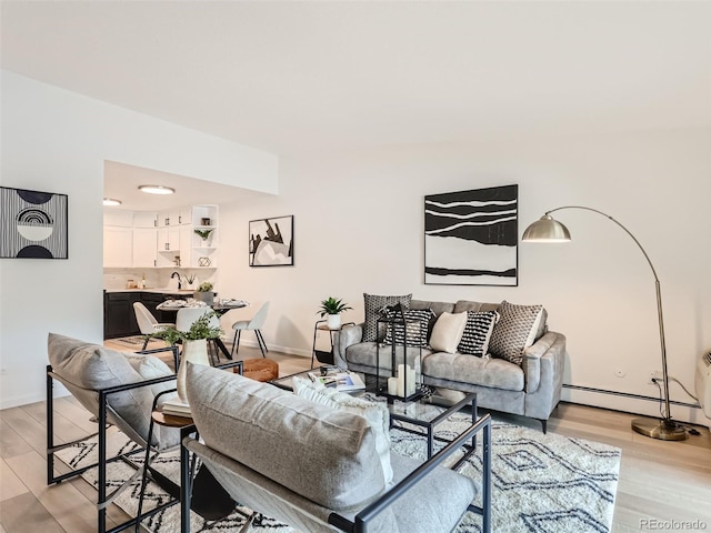 living room with light hardwood / wood-style flooring and a baseboard heating unit