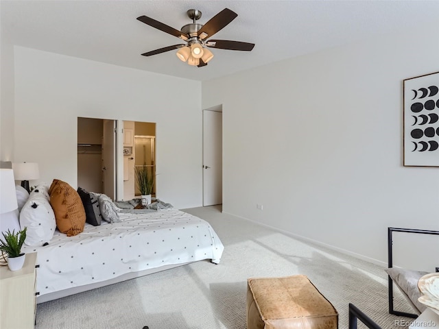 bedroom with ceiling fan, carpet flooring, a spacious closet, and a closet