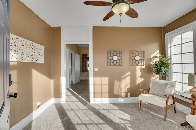 sitting room with a ceiling fan and light carpet