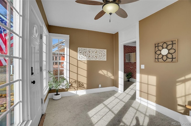 interior space featuring light carpet, ceiling fan, and baseboards