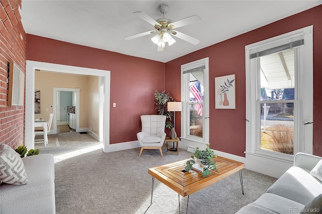 carpeted living room with plenty of natural light, baseboards, and ceiling fan