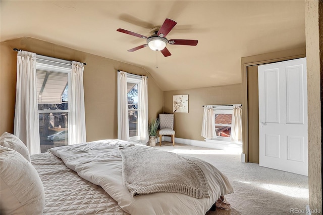 bedroom featuring carpet, multiple windows, lofted ceiling, and baseboards