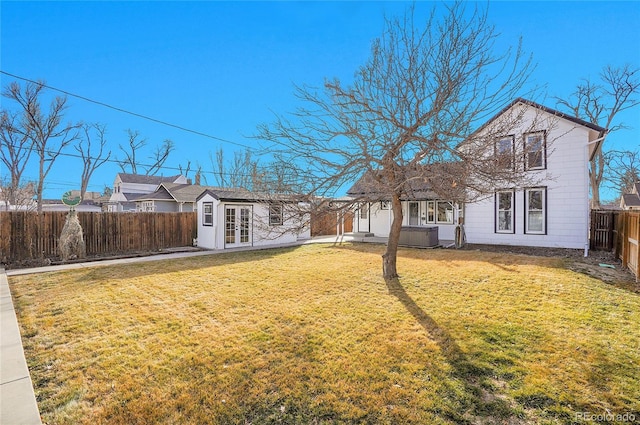 view of yard with french doors and a fenced backyard