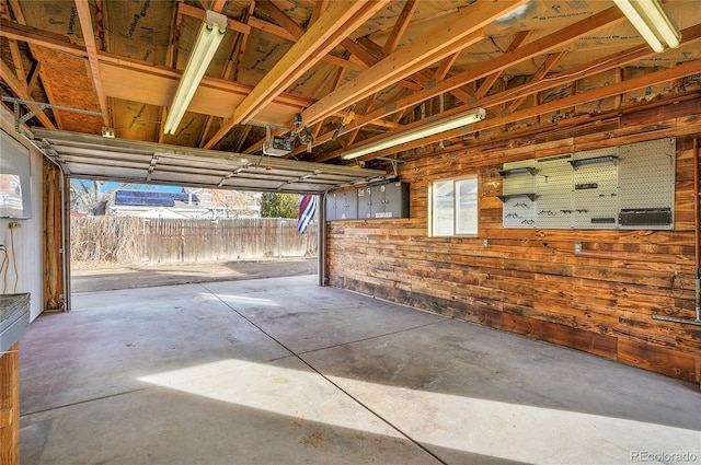 garage with a garage door opener and wooden walls