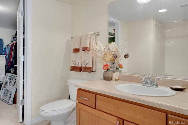 12348 W Gould Ave, Littleton, CO 80127 - bathroom featuring vanity, a spacious closet, and toilet