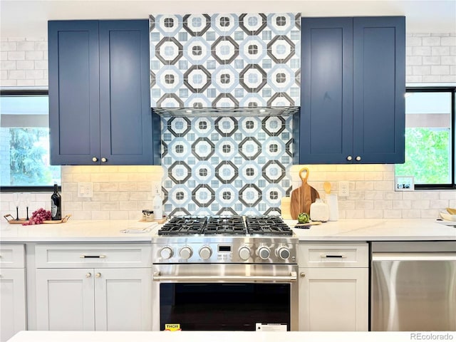 4192 S Vrain St, Denver, CO 80236 - kitchen with appliances with stainless steel finishes, light countertops, backsplash, and blue cabinetry