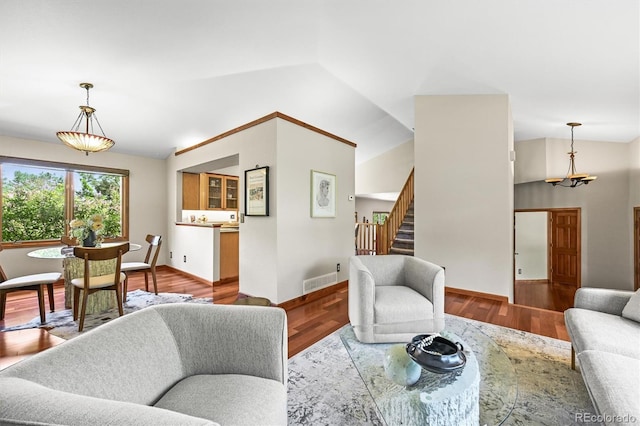 11072 Zephyr St, Broomfield, CO 80021 - living area featuring stairs, vaulted ceiling, baseboards, wood finished floors, and a chandelier