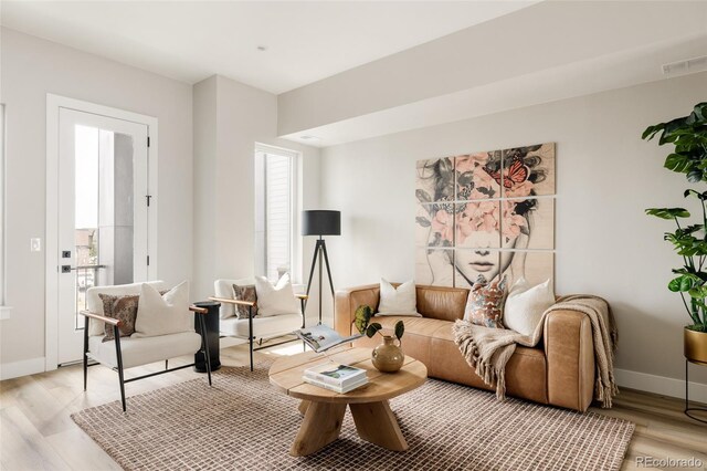 living area featuring light wood-style floors and baseboards