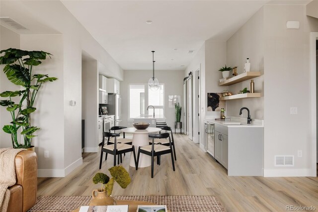 dining room with light wood-style flooring, baseboards, and a chandelier